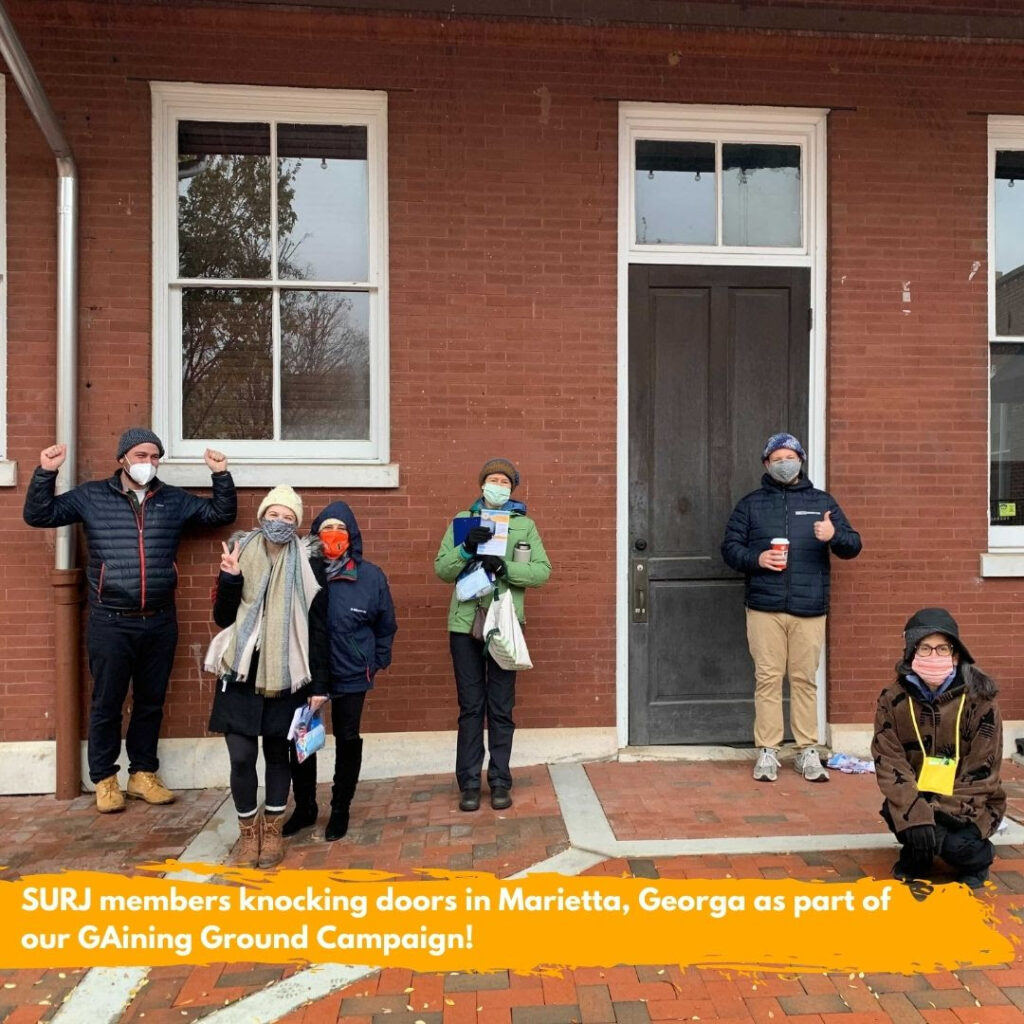 Image shows a group of 6 white folks, bundled up and wearing masks, outside a red brick building, holding canvassing literature. The text overlaid on the image reads: "SURJ members knocking doors in Marietta, Georgia as part of our GAining Ground campaign."