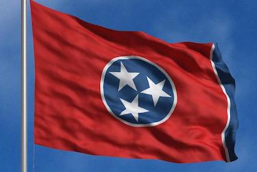 image shows the tennessee state flag flying against a blue sky