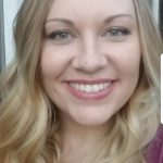 Photo shows a white woman with long wavy blonde hair, smiling.